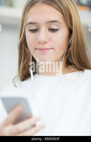 Teenage Girl Streaming Music From Mobile Phone Stock Photo