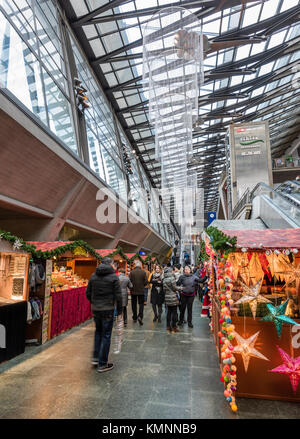 Lucerne, Switzerland - 2 Dec 2017: Christmas shoppers are passing by the market stalls of a little indoor Christmas market inside Lucerne main station Stock Photo