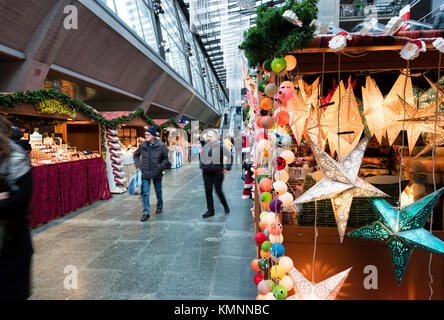 Lucerne, Switzerland - 2 Dec 2017: Christmas shoppers are passing by the market stalls of a little indoor Christmas market inside Lucerne main station Stock Photo