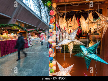 Lucerne, Switzerland - 2 Dec 2017: Christmas shoppers are passing by the market stalls of a little indoor Christmas market inside Lucerne main station Stock Photo