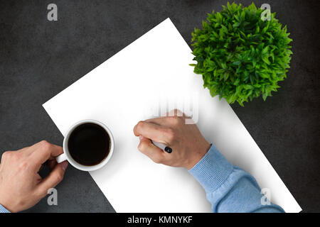 Man writing on a digital writing pad connected to a laptop sitting on a