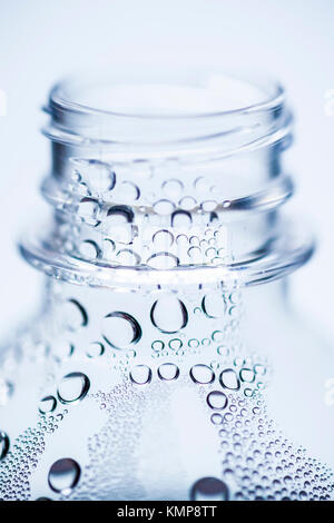 The top of a single use plastic bottle with bubbles / water droplets inside. Stock Photo