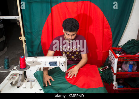 Dhaka, Bangladesh. 09th Dec, 2017. Victory day is a national holiday in Bangladesh celebrated on December 16 to commemorate the victory of the Allied forces High Command over the Pakistani forces in the Bangladesh Liberation War in 1971. A young tailor sewing cloth and making Bangladeshi national flags for selling Upcoming 16 December events. Credit: Jahangir Alam Onuchcha/Alamy Live News Stock Photo