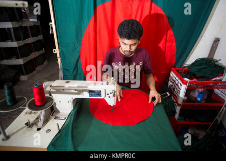 Dhaka, Bangladesh. 09th Dec, 2017. Victory day is a national holiday in Bangladesh celebrated on December 16 to commemorate the victory of the Allied forces High Command over the Pakistani forces in the Bangladesh Liberation War in 1971. A young tailor sewing cloth and making Bangladeshi national flags for selling Upcoming 16 December events. Credit: Jahangir Alam Onuchcha/Alamy Live News Stock Photo