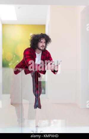 young freelancer in bathrobe working from home using tablet computer Stock Photo