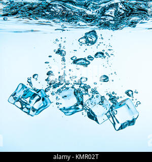 Ice cubes falling into the water sinking to the bottom. Abstract background. Stock Photo