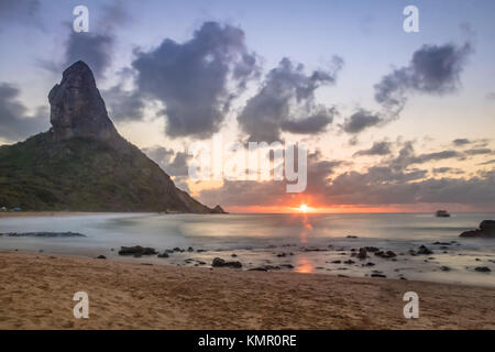 Sunset at Praia da Conceicao Beach with Morro do Pico on background - Fernando de Noronha, Pernambuco, Brazil Stock Photo