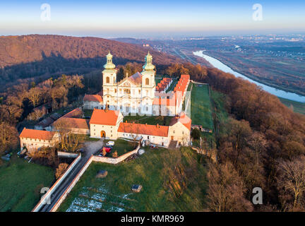 Camaldolese monastery and baroque church in the wood on the hill in Bielany, Krakow, Poland , Aerial view in sunset light with Vistula River Stock Photo