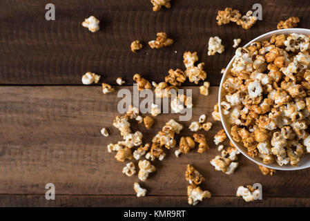 caramel popcorn on wooden table background. caramel flavoured popcorn in bowl Stock Photo