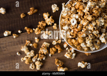 caramel popcorn on wooden table background. caramel flavoured popcorn in bowl Stock Photo