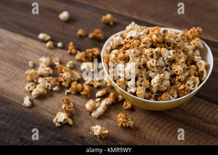 caramel popcorn on wooden table background. caramel flavoured popcorn in bowl Stock Photo
