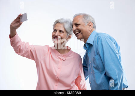 Happy senior couple taking selfie using mobile phone Stock Photo