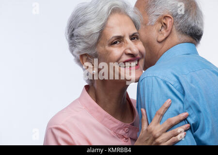 Close up of older couple whispering Stock Photo