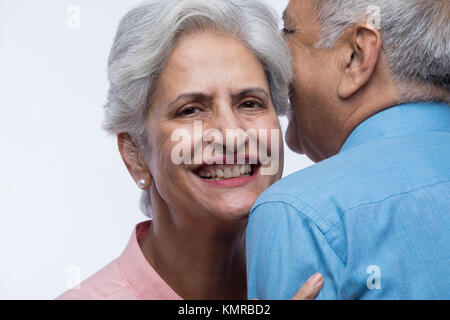 Close up of senior couple whispering Stock Photo
