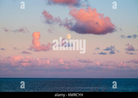 Full moon at sunset over sea Stock Photo