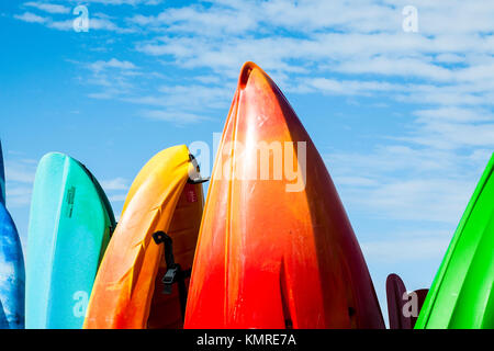 A line up of sea kayaks and canoes for hire on the seafront. Stock Photo