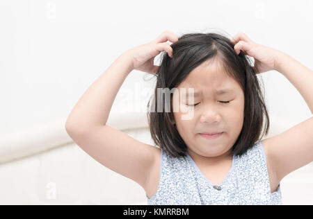 kid with freckles scratching his hair for head lice or allergies, Health care concept Stock Photo
