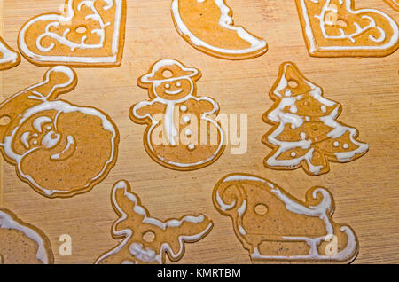 Christmas background: Christmas ginger biscuits of various shapes with white icing on a wooden board Stock Photo