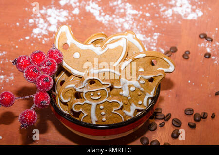 Christmas decoration: Christmas gingerbreads with white icing in a colorful bowl on a wooden board Stock Photo