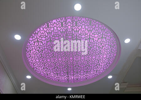 Modern layered ceiling with embedded lights and stretched ceiling inlay, light turned on Stock Photo