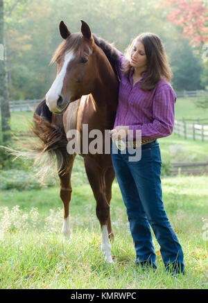 Young woman posing with Quarter Horse mare Stock Photo