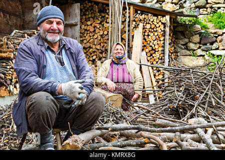Elderly Turkish couple smiling and looking while chopping the fire wood in Trabzon, Turkey. Stock Photo