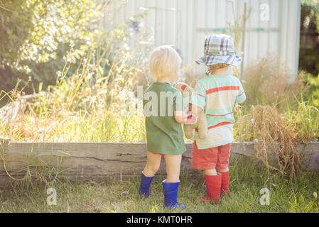 Rear view of brothers standing on field Stock Photo