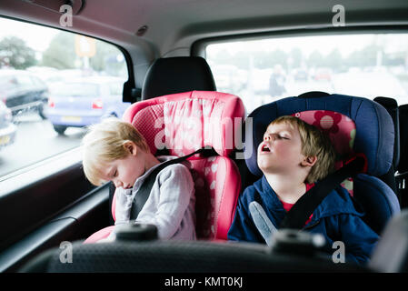Tired brothers sleeping in car