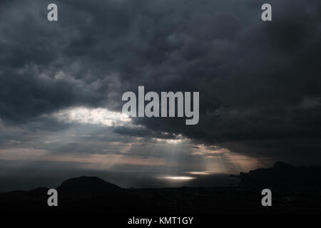 ominous clouds and the bursting rays of light over the gulf sea Stock Photo