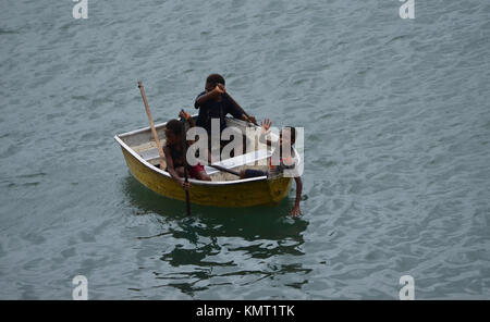 Depend on each other, three boys in a small boat on the ocean in Papua New Guinea Stock Photo