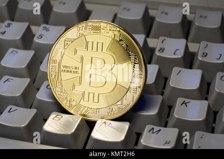 Gold-colored Bitcoin cryptocurrency coin on a computer keyboard Stock Photo