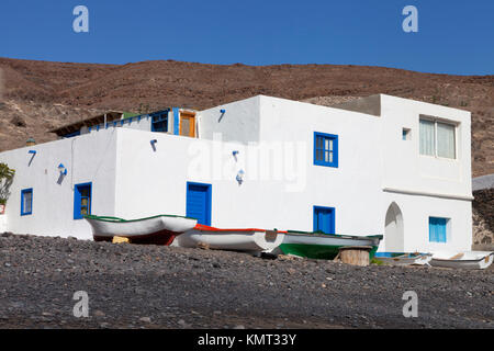 White stone houses on a sea shore of volcanic beach with wooden small  fishing boats Stock Photo - Alamy