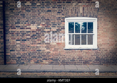 White wooden sash window on a restored brick wall of a Victorian house residential building. Vintage effect Stock Photo