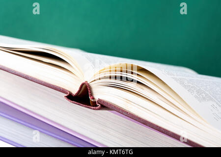 Colorful stack of textbooks with open book on its top Stock Photo