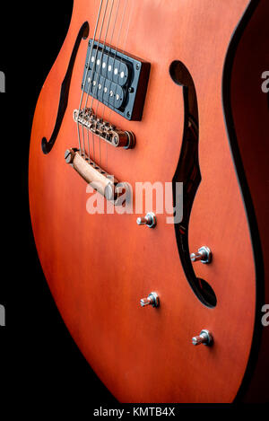 Hollow body electric guitar with humbuckers. Macro shot, black background, dark key Stock Photo