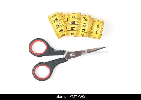 Sewing small scissors with yellow measuring tape on a white background, sewing equipment Stock Photo