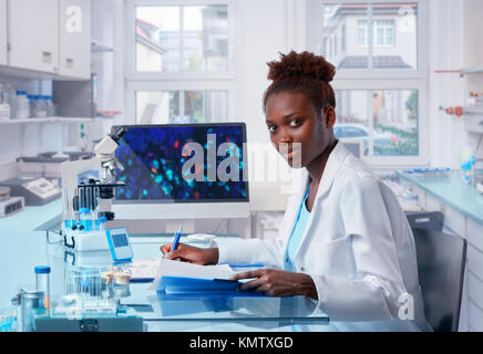 Female African scientist, medical worker, tech or graduate student works in modern biological laboratory. This image is toned.