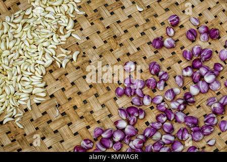 Fresh baby onions and garlic lying on a basket patterned background Stock Photo