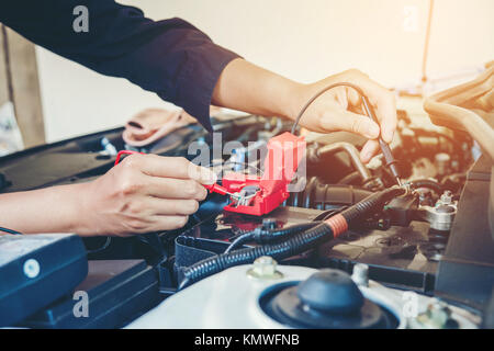 Hands check battery car mechanic working in auto repair service Stock Photo