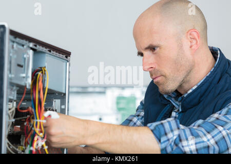 computer engineer working on broken console Stock Photo