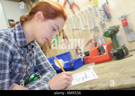 craftswoman taking notes in the workshop Stock Photo