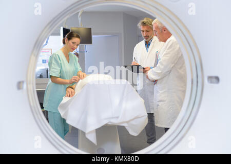 View of medical team through circular mri scanner Stock Photo