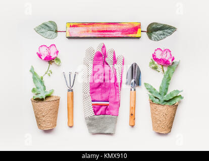 Pink Gardening equipment  flat lay for planting, weeding, pruning with garden tools, flowers seedling plant in pot and Gloves on white table backgroun Stock Photo