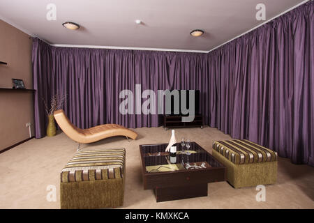 Beautiful modern interior with a convenient armchair from a genuine leather, a sofa, the big television screen and a beautiful floor vase Stock Photo
