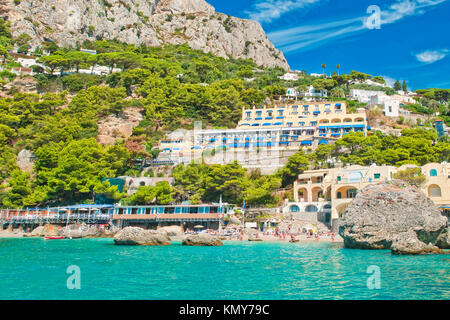 view of Marina Piccola beach from sea with mountain, hotels and restaurants behind it on sunny summer day, Capri, Italy Stock Photo