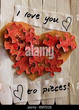 close up of hand made popsicle stick sign with puzzle pieces in the shape of a heart that says i love you to pieces Stock Photo
