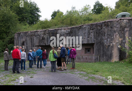 A group on a guided tour outside an entrance to the Maginot Line site of Four À Chaux de Lembach, Alsace Stock Photo