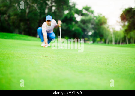 Golf player marking ball on the putting green Stock Photo