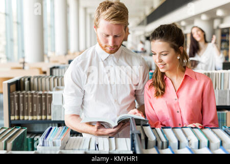 Two students reading and studying in library Stock Photo