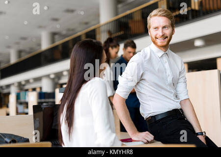 A group of academics studying in the library and conversing Stock Photo
